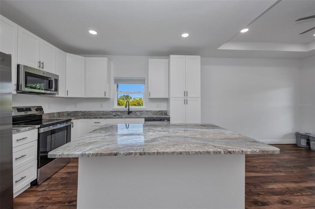 409 Carmalita Street, Unit 111 & 112 Punta Gorda, FL 33950 - Photo 8 of 75 a kitchen with kitchen island granite countertop a sink stove and microwave