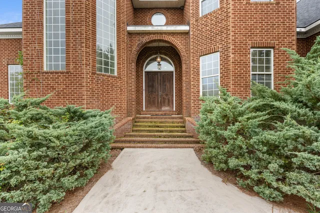a view of a house with large windows and a flower plants