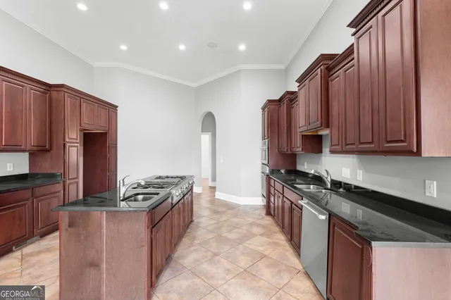 a kitchen with stainless steel appliances granite countertop a stove a sink and a refrigerator
