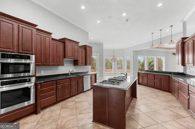 a kitchen with stainless steel appliances granite countertop a stove a sink dishwasher and a microwave oven with cabinets