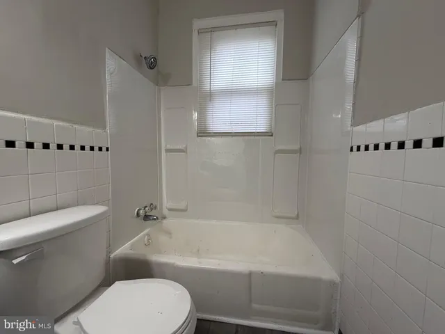 a white toilet sitting next to a bath tub