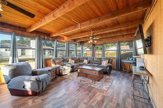 a living room with furniture a flat screen tv and kitchen view