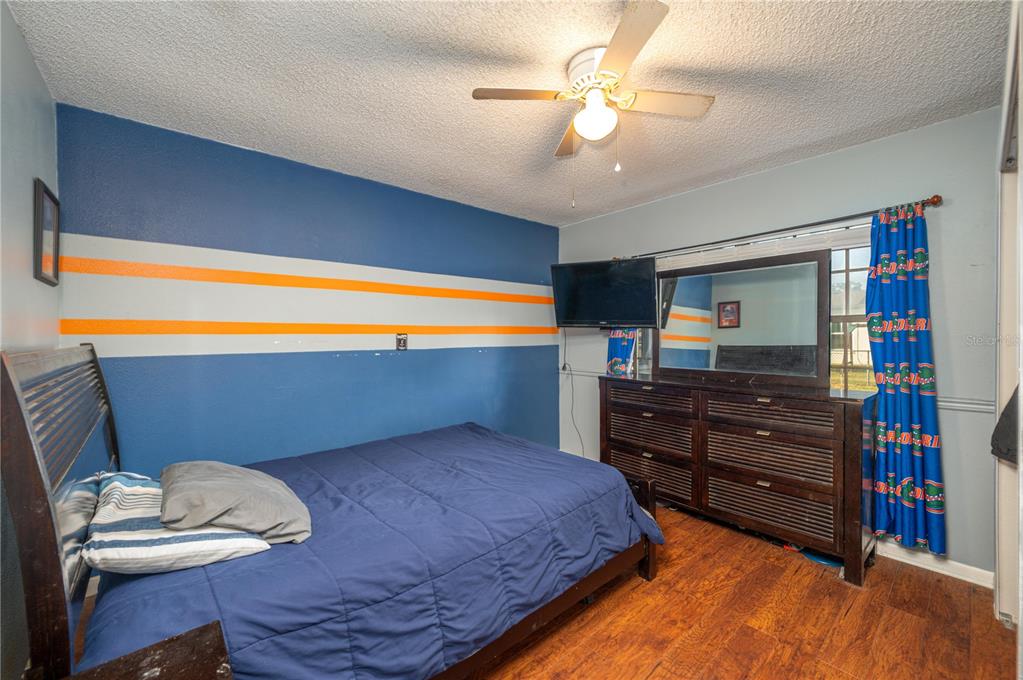 1330 Spring Court Bartow, FL 33830 - Photo 27 of 40 a bedroom with a bed and a bookshelf with wooden floor