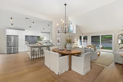 a kitchen with stainless steel appliances kitchen island granite countertop a sink a stove and a wooden floors