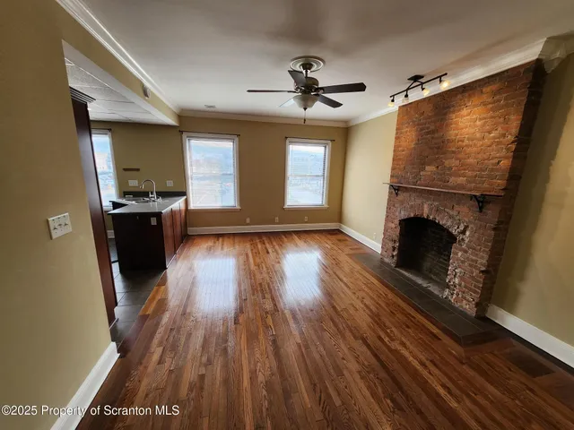 a living room with hard wood floors and a fireplace