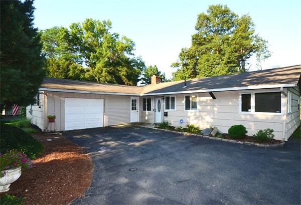 a view of a house with a yard and a large tree