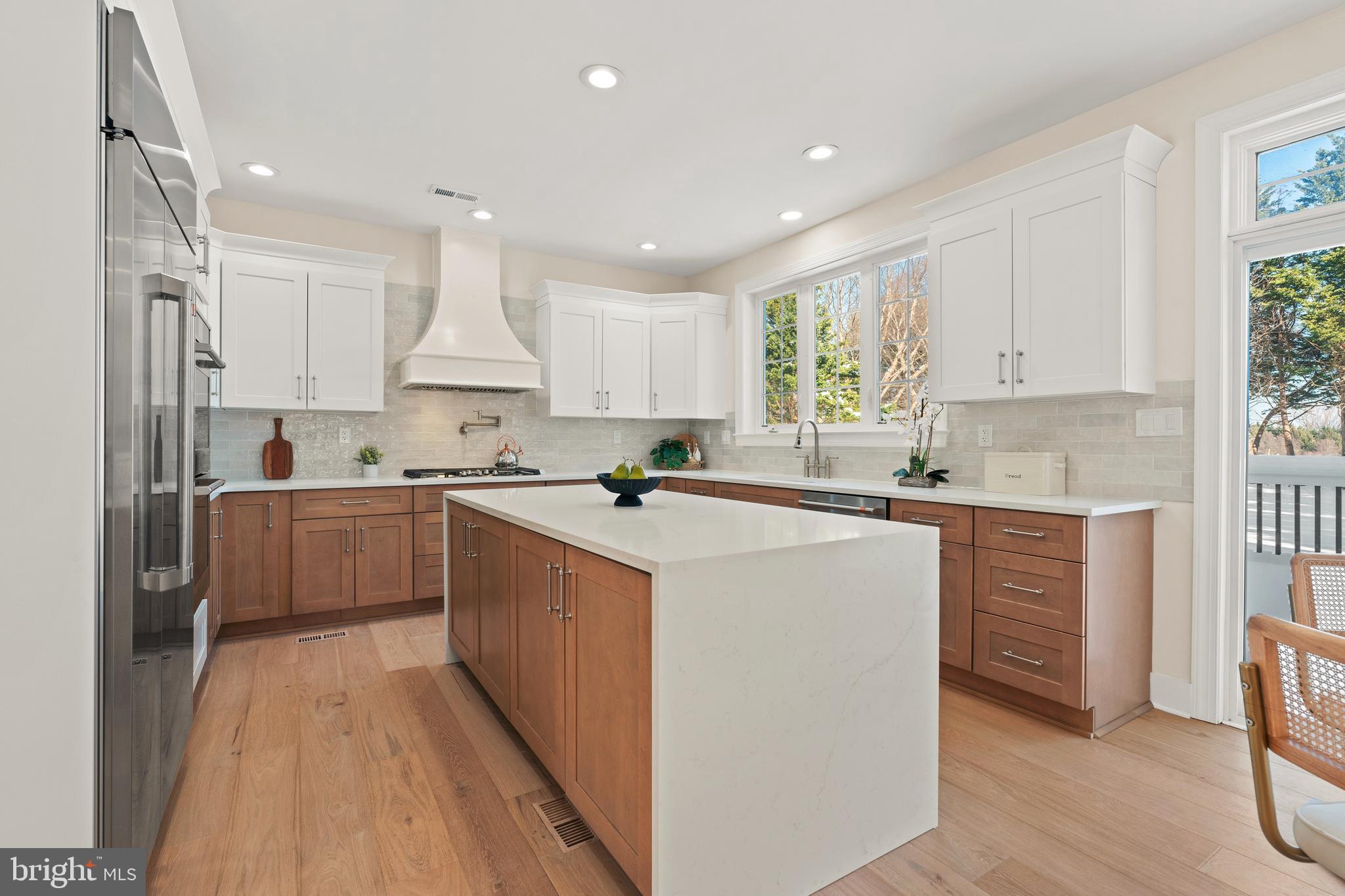 1586 Brookfield Road Newtown, PA 18940 - Photo 9 of 64 a kitchen with kitchen island granite countertop a stove a sink a refrigerator and white cabinets with wooden floor