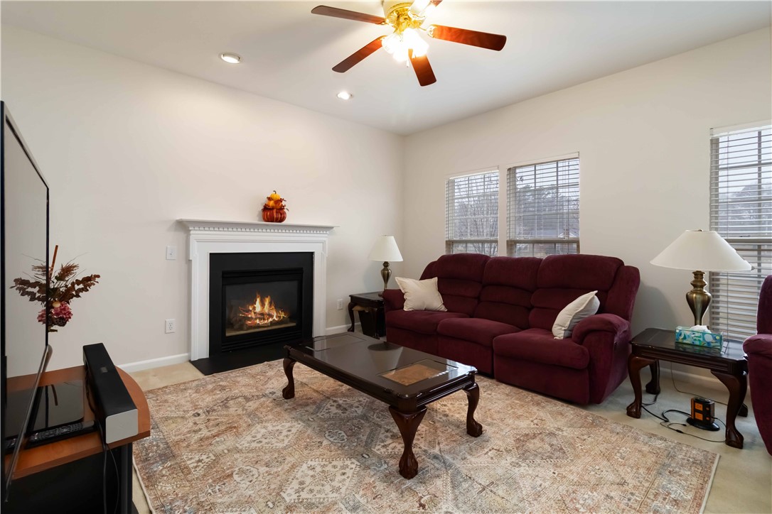 215 Ridge Bay Court Greenville, SC 29611 - Photo 16 of 35 Warm living area featuring a cozy fireplace, ample natural light, and comfortable seating.