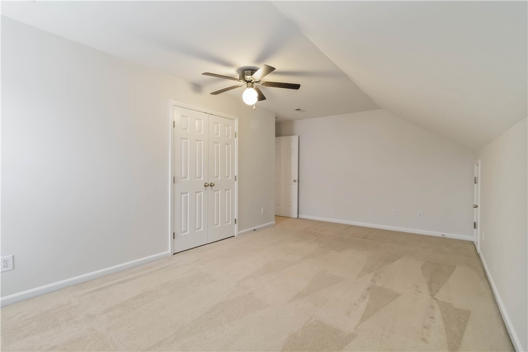 215 Ridge Bay Court Greenville, SC 29611 - Photo 22 of 35 This spacious bedroom offers comfortable carpeting and a ceiling fan, perfect for any season.