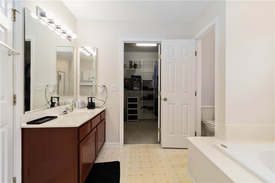 215 Ridge Bay Court Greenville, SC 29611 - Photo 29 of 35 This primary bathroom offers a vanity with ample counter space and an adjacent walk-in closet.