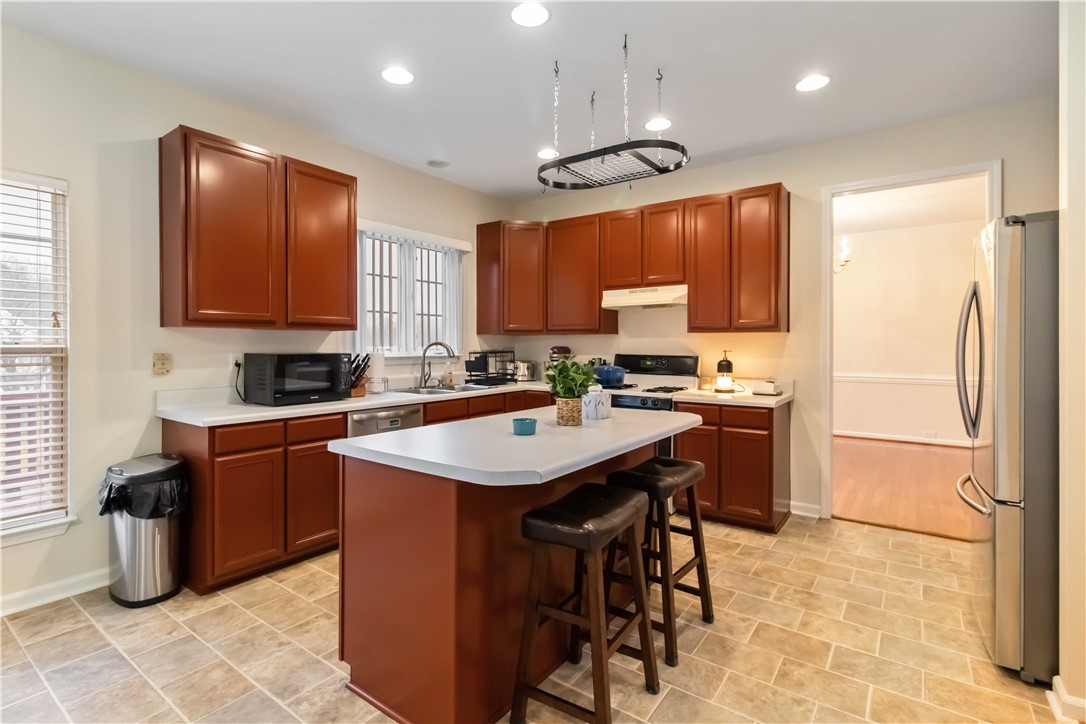 215 Ridge Bay Court Greenville, SC 29611 - Photo 10 of 35 This spacious kitchen offers rich cabinetry, a functional island, and convenient modern appliances, perfect for everyday living.