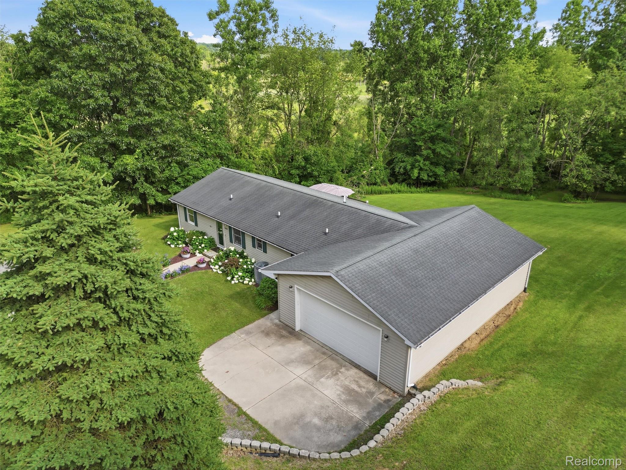 5003 Mason Road Howell, MI 48843 - Photo 48 of 59 Ranch-style residence featuring a two-car attached garage, light gray siding, and a dark shingle roof