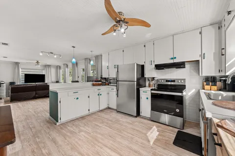 a kitchen with white cabinets and stainless steel appliances