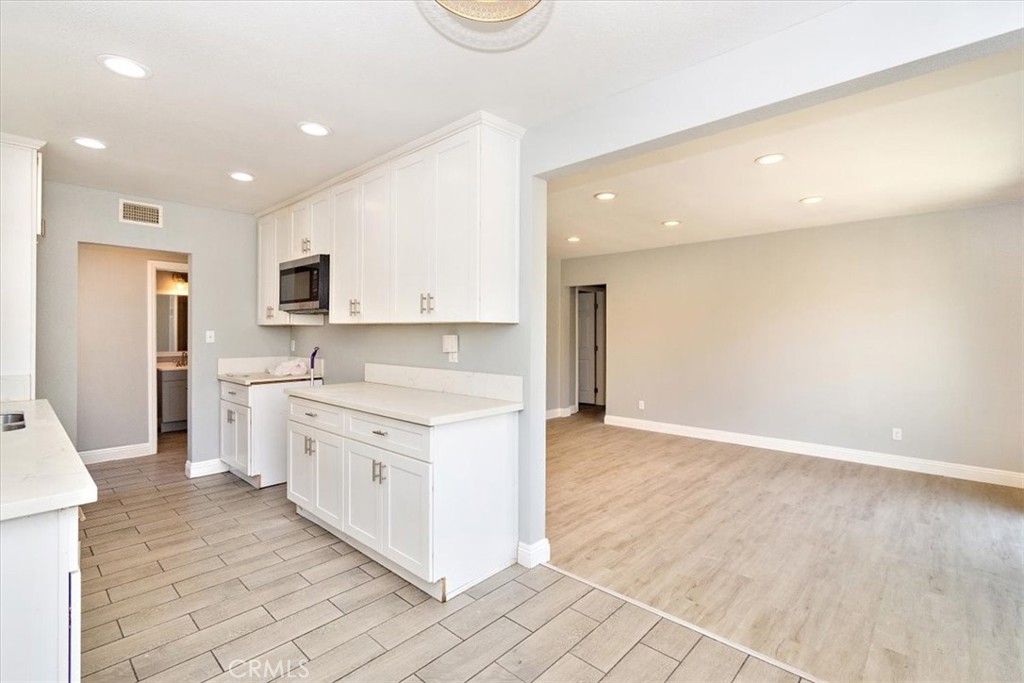 1716 West Piru Street Compton, CA 90222 - Photo 6 of 17 a open kitchen with stainless steel appliances granite countertop a stove a sink and a refrigerator with white cabinets
