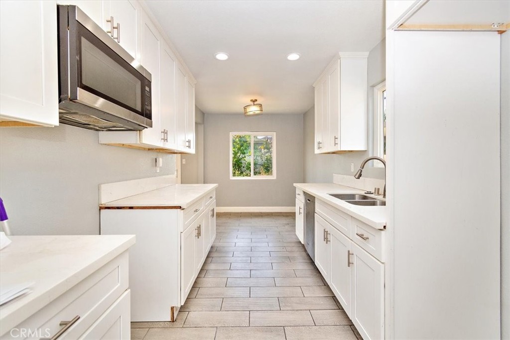 1716 West Piru Street Compton, CA 90222 - Photo 7 of 17 a kitchen with a sink stove and microwave