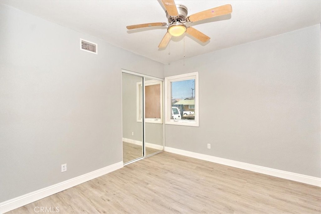 1716 West Piru Street Compton, CA 90222 - Photo 8 of 17 an empty room with wooden floor fan and windows