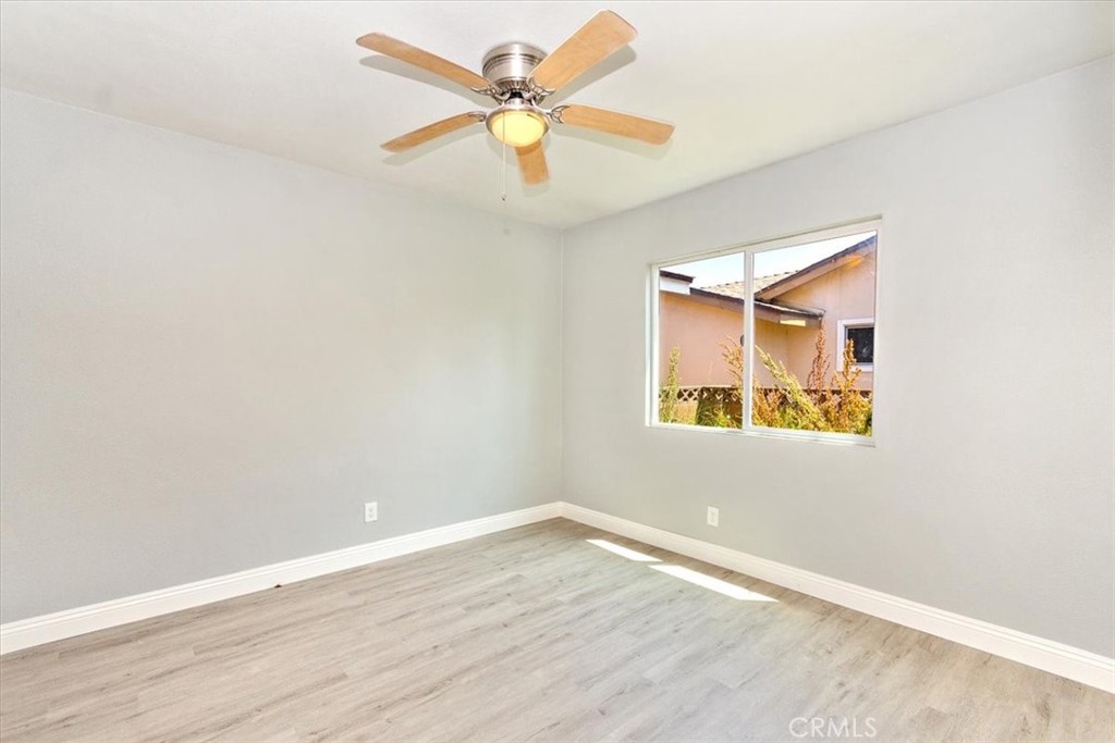 1716 West Piru Street Compton, CA 90222 - Photo 9 of 17 an empty room with a window and a ceiling fan