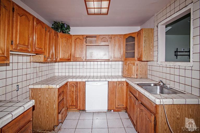 311 West Bard Road Oxnard, CA 93033 - Photo 4 of 10 a kitchen with granite countertop cabinets sink and a stove