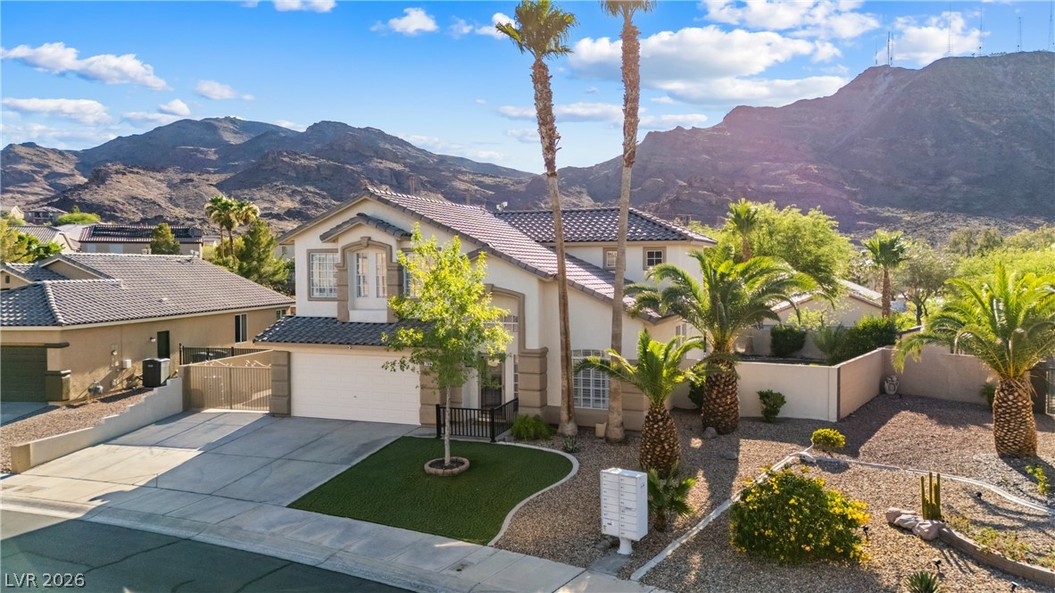 708 Vortex Avenue Henderson, NV 89002 - Photo 69 of 71 A desert oasis, this two-story residence is framed by rugged mountains and features a well-maintained lawn and mature palm trees.