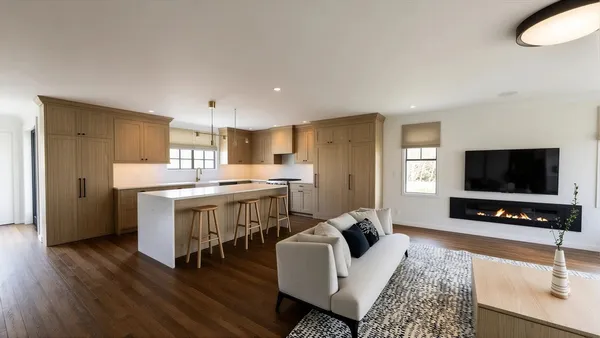 a living room with stainless steel appliances furniture and a flat screen tv