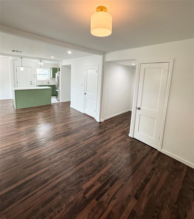 6442 Latta Street Dallas, TX 75227 - Photo 5 of 12 an empty room with wooden floor cabinet and windows