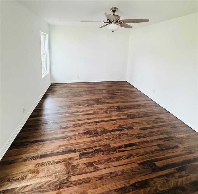 6442 Latta Street Dallas, TX 75227 - Photo 7 of 12 an empty room with wooden floor fan and windows