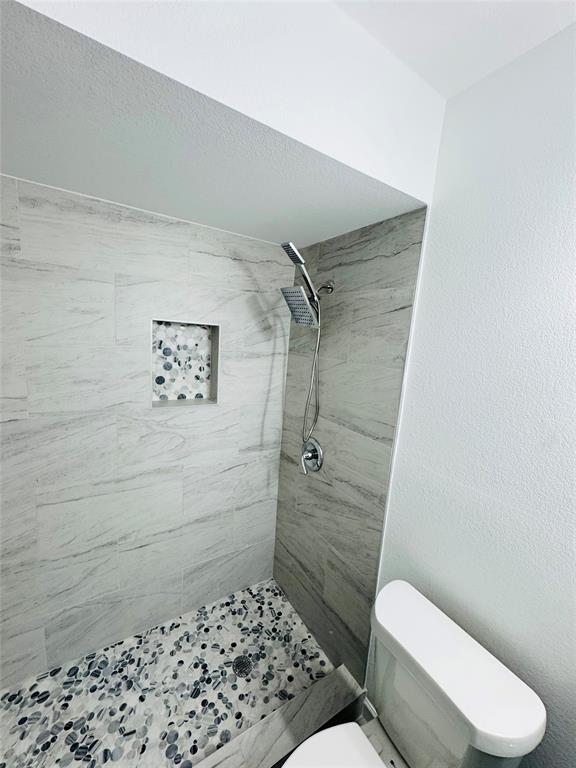 6442 Latta Street Dallas, TX 75227 - Photo 8 of 12 a bathroom with a toilet and a shower
