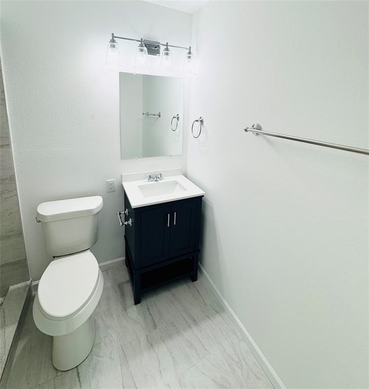 6442 Latta Street Dallas, TX 75227 - Photo 9 of 12 a bathroom with a toilet sink and mirror