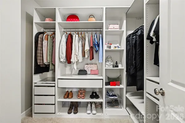 a view of walk in closet with clothes and shoes