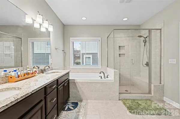 a spacious bathroom with a tub sink shower and mirror