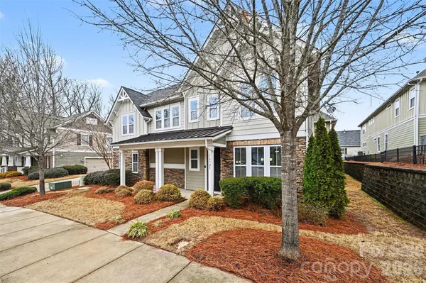 a front view of a house with a yard and potted plants