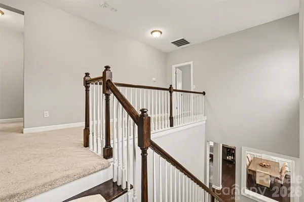 a view of staircase with railing and white walls