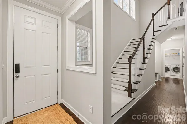 a view of a hallway with stairs and wooden floor
