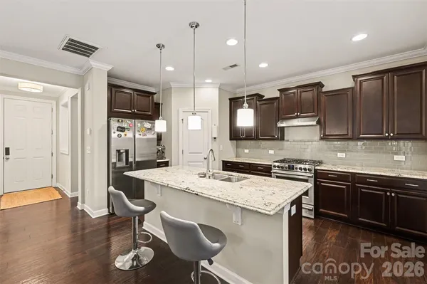 a kitchen with stainless steel appliances granite countertop a sink stove and refrigerator