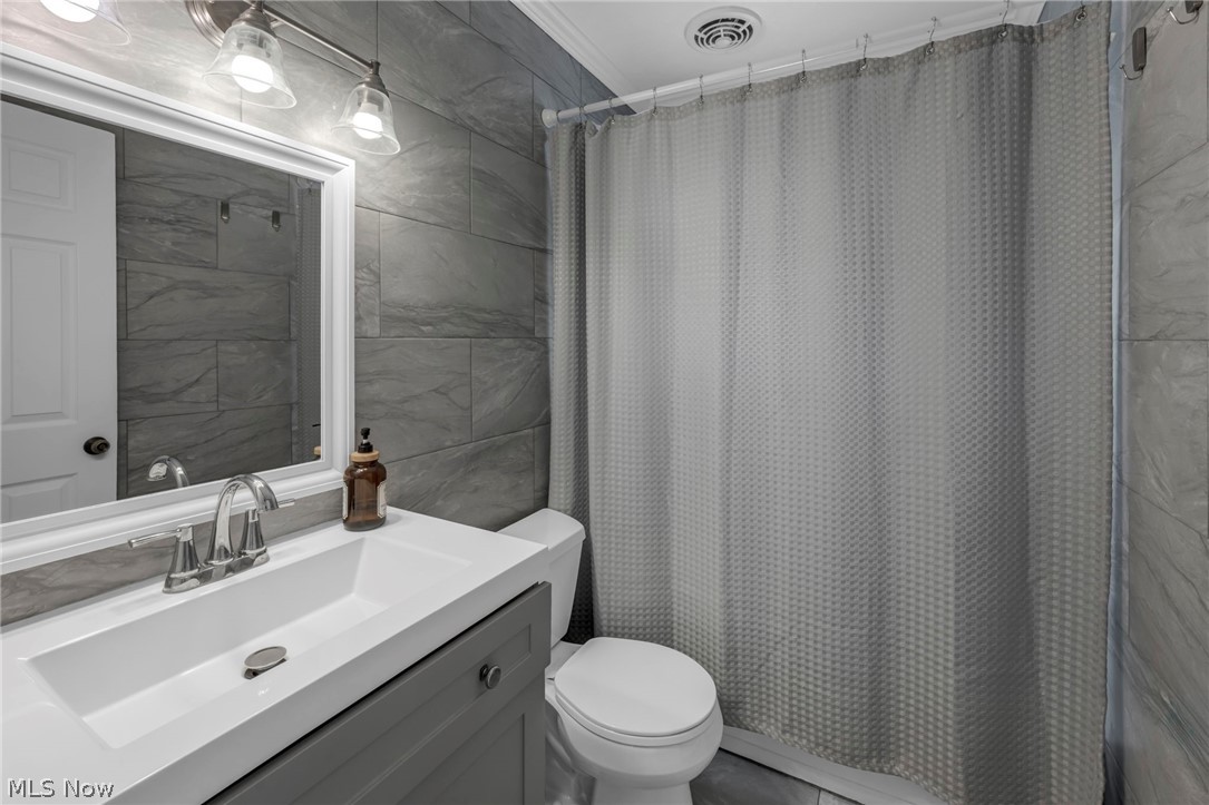 5200 Royalton Road, Unit 9B North Royalton, OH 44133 - Photo 22 of 27 Full bathroom with tile walls, vanity, and ornamental molding