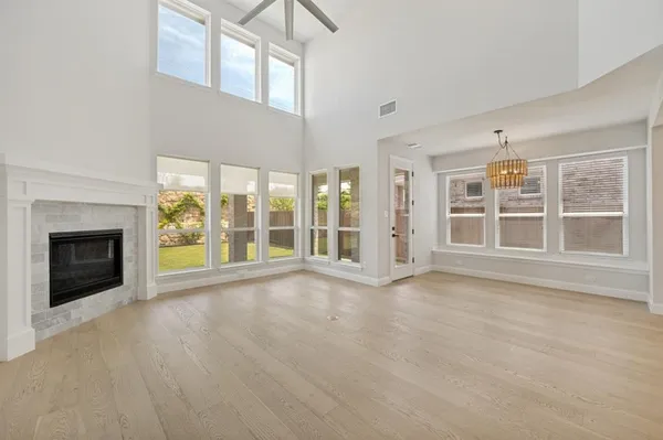 a view of an empty room with a fireplace and a window