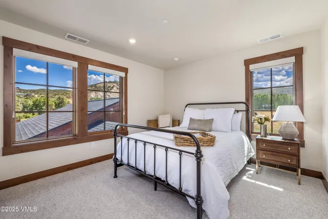 a bedroom with a bed and a large window