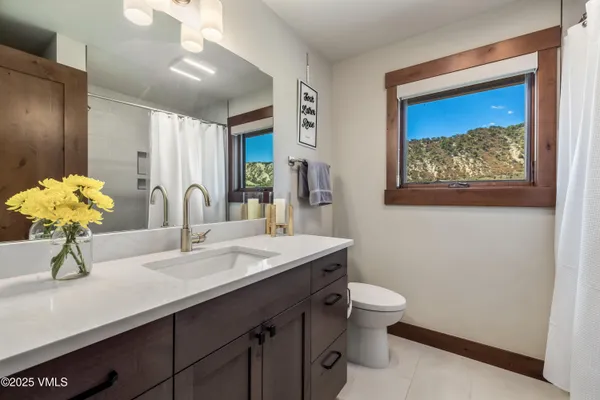 a bathroom with a sink a toilet and a mirror