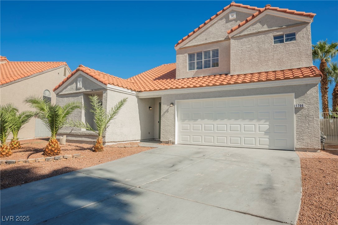 Mediterranean / spanish-style home featuring driveway, stucco siding, a tile roof, and a garage