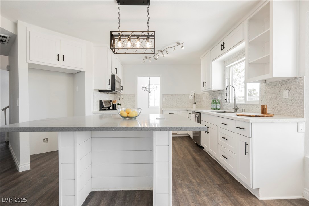 1706 Toltec Circle Henderson, NV 89014 - Photo 11 of 21 Kitchen with a kitchen island, dark wood finished floors, white cabinetry, and decorative backsplash
