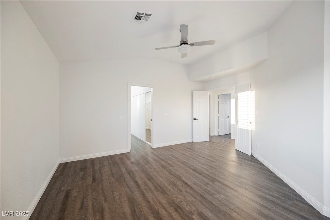 1706 Toltec Circle Henderson, NV 89014 - Photo 16 of 21 Empty room with dark wood-type flooring, vaulted ceiling, and a ceiling fan