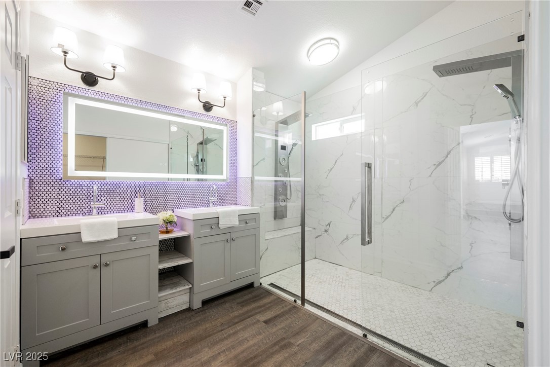 1706 Toltec Circle Henderson, NV 89014 - Photo 6 of 21 Full bathroom with a marble finish shower, vanity, dark wood-type flooring, vaulted ceiling, and tasteful backsplash