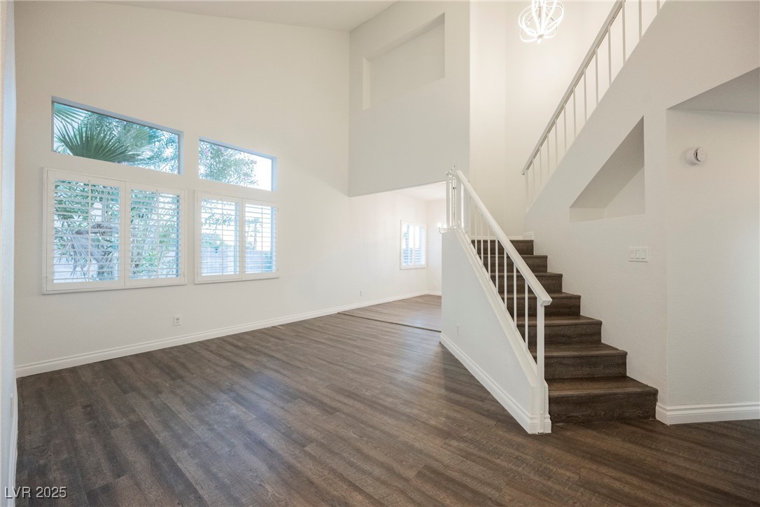 1706 Toltec Circle Henderson, NV 89014 - Photo 9 of 21 Staircase with a high ceiling, wood finished floors, and a chandelier
