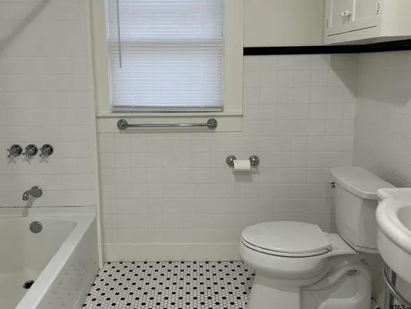 a bathroom with a toilet a sink and bathtub