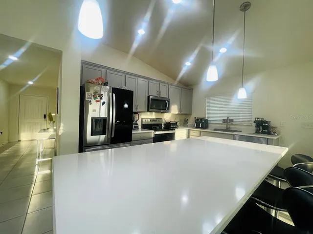 a large white kitchen with a refrigerator a stove and a sink