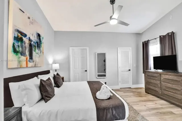 a kitchen with stainless steel appliances a stove a sink dishwasher and a refrigerator with wooden floor