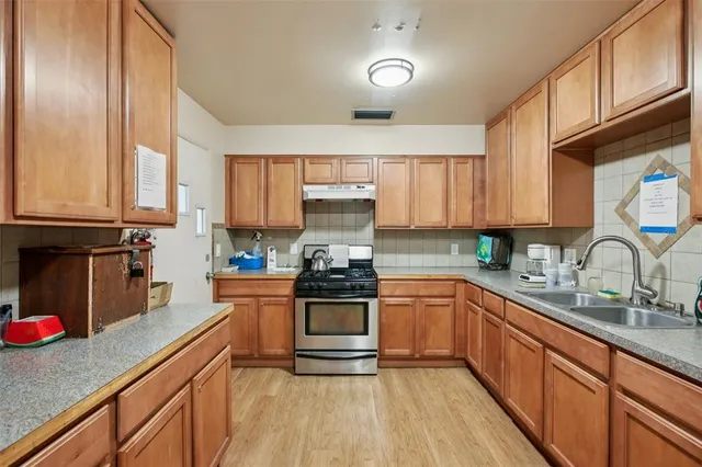 a kitchen with stainless steel appliances granite countertop a stove sink and cabinets