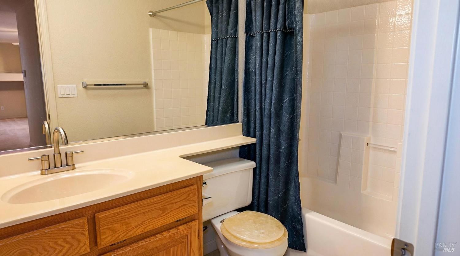 4124 Singletree Way Fairfield, CA 94533 - Photo 24 of 43 a bathroom with a sink a toilet a mirror and shower