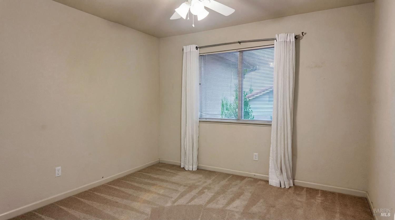 4124 Singletree Way Fairfield, CA 94533 - Photo 40 of 43 an empty room with a fan and a window
