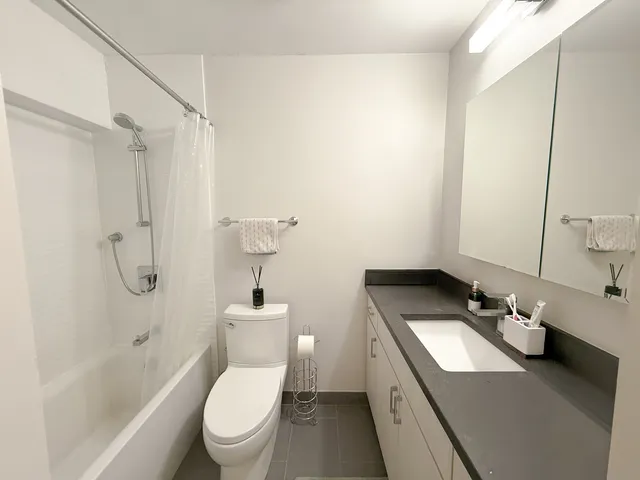 a bathroom with a granite countertop sink toilet and shower